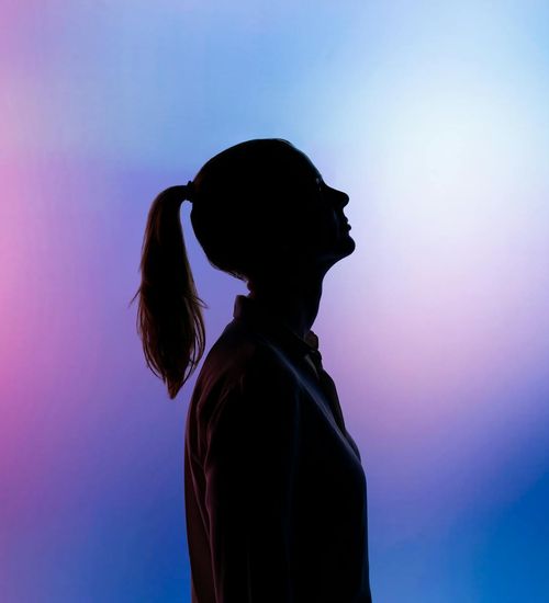 Silhouette of a person in a calm yoga pose against a minimal background.
